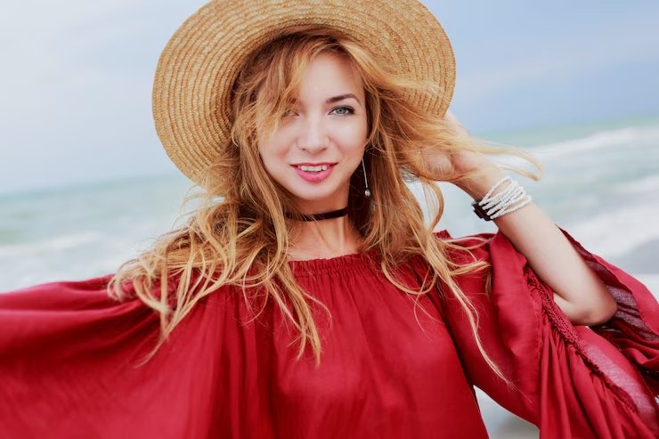  lovely-woman-straw-hat-trendy-red-summer-dress-posing-near-ocean-waves-candid-smile